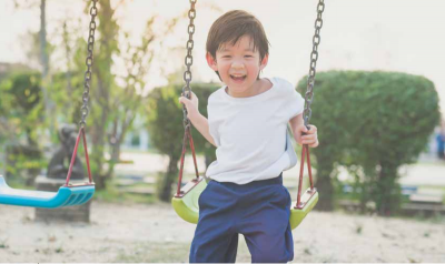 Boy smiles has he plays on the swing 